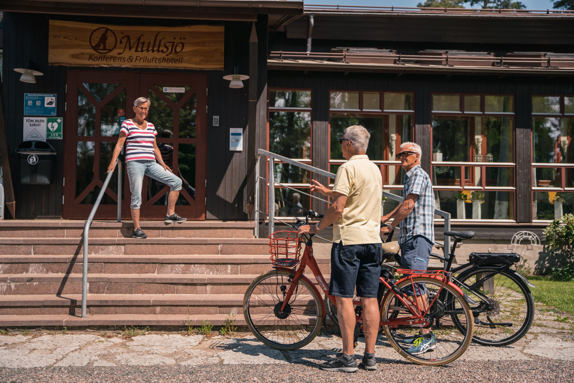 Två cyklister som stannat till utanför entrén vid ett hotell i Mullsjö