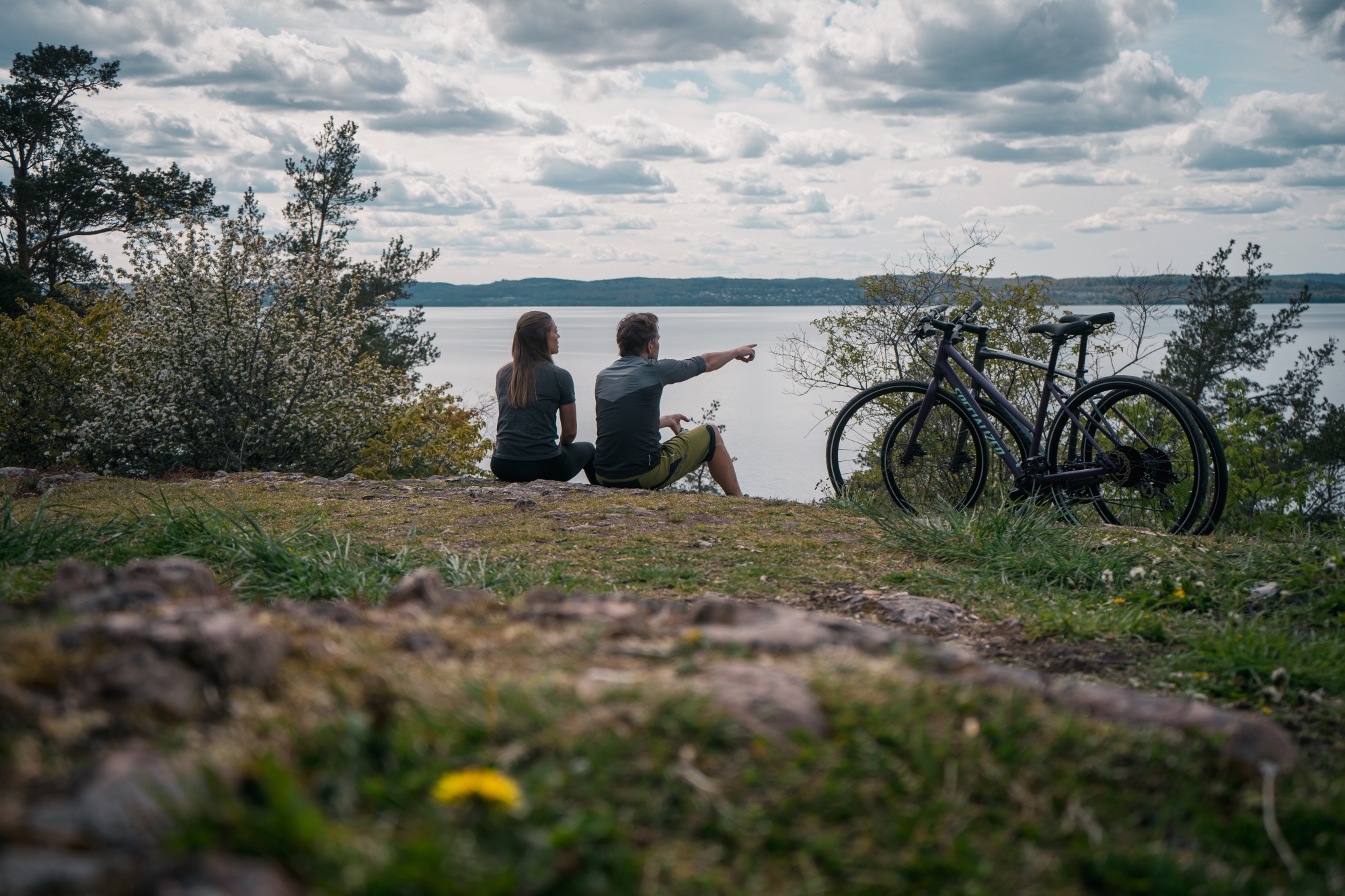 Två människor på en klippa som blickar ut mot Vättern.