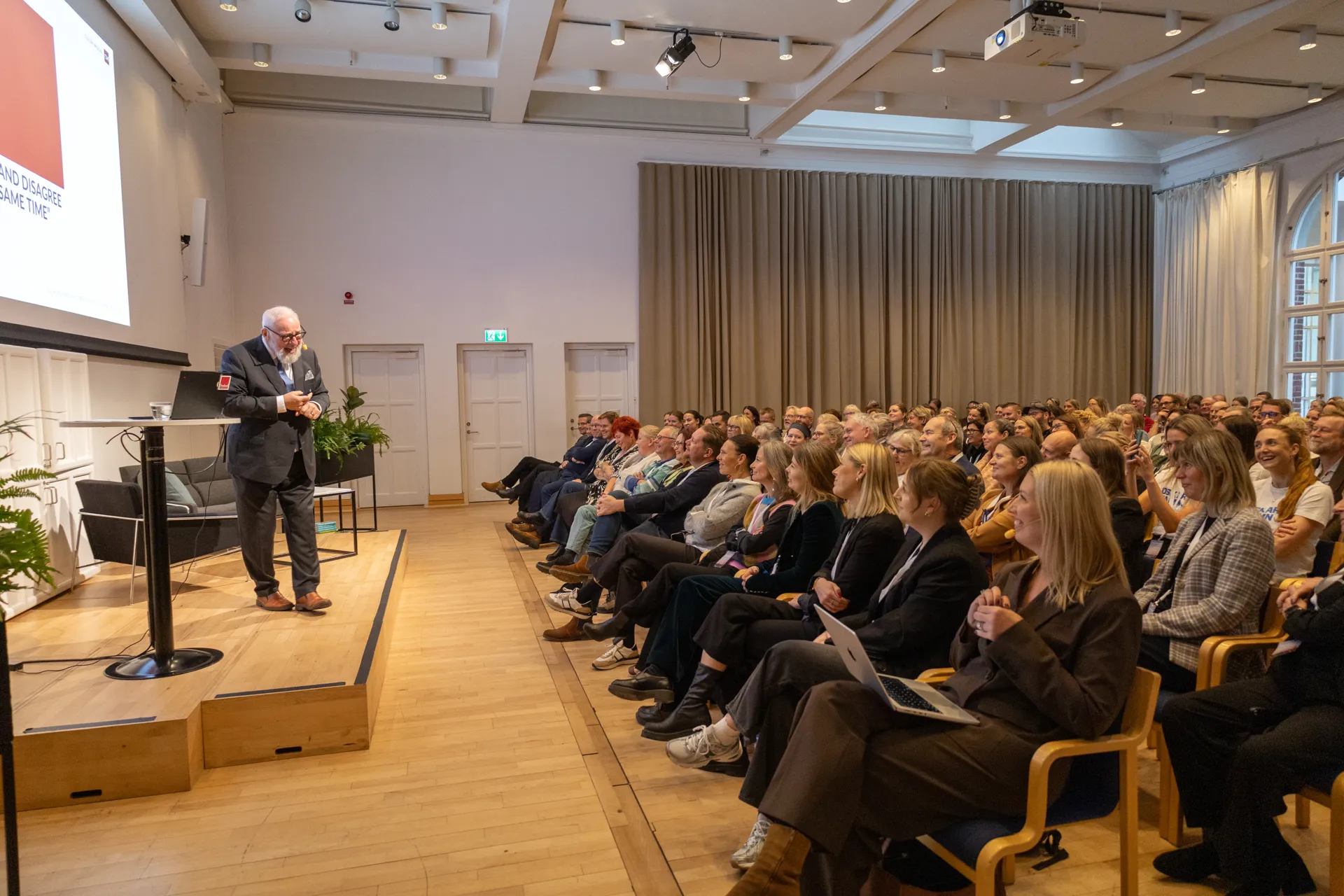 Man som föreläser för stor grupp människor.