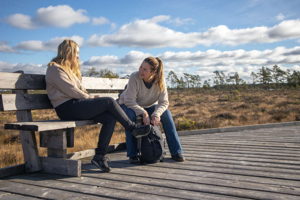 två kvinnor som sitter ute i solen