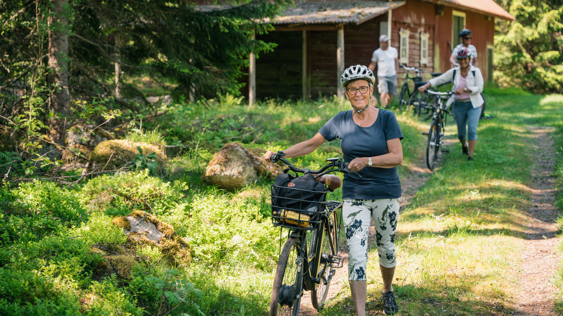 Människor som går ner för en backe med cyklar